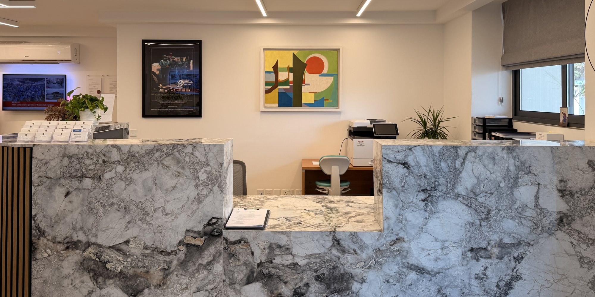 Marble reception desk and artwork at Demajo Medical, Mellieħa