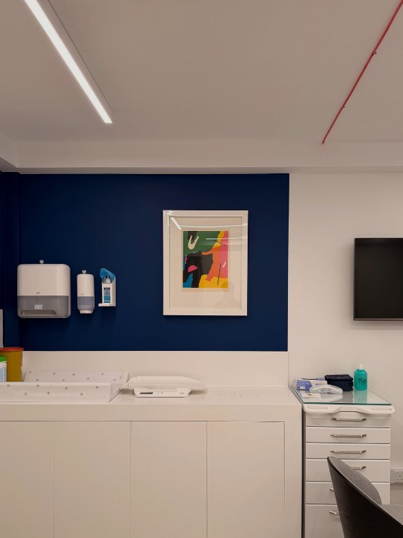 Paediatric room at Demajo Medical with navy feature wall and baby changing station