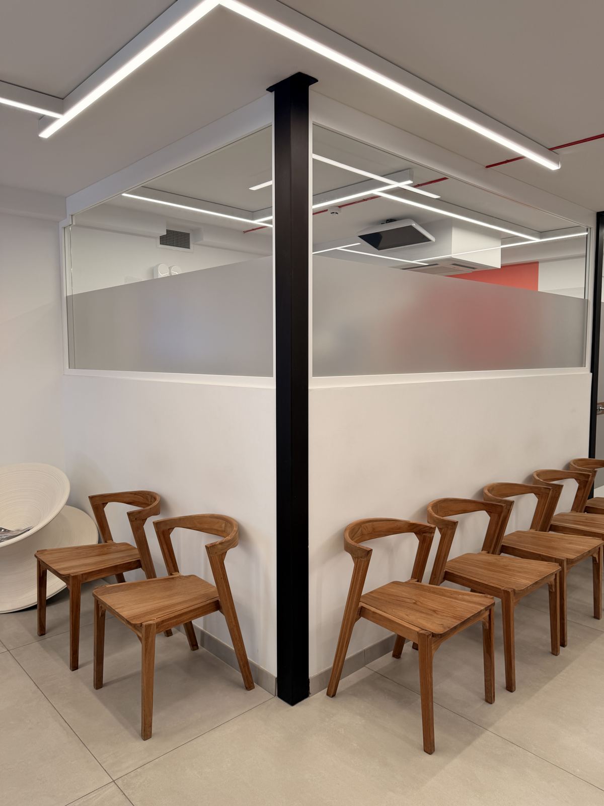 Waiting lounge with teak chairs and frosted glass partitions